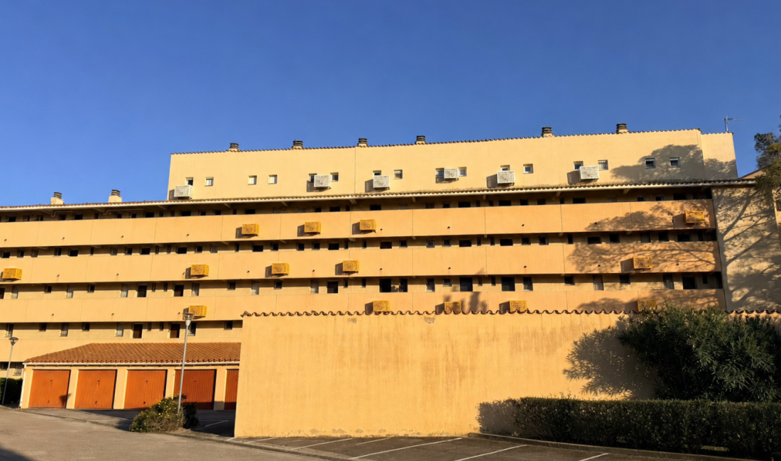 Cache-clim installés sur une façade résidentielle avec cyprès au premier plan